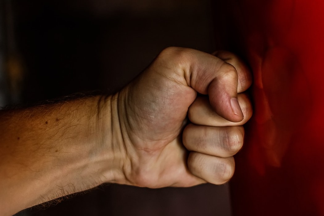 Clenched fist hitting a wall.