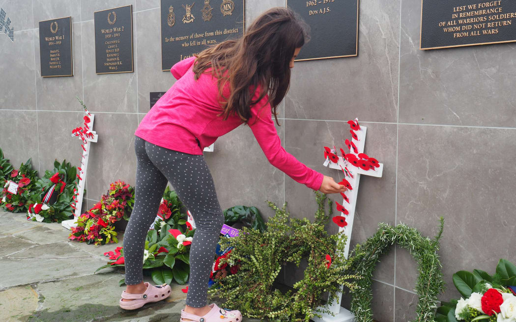 Seven-year-old Paige Webb-Higgs, of Auckland, pays her respects during the morning service at Kerikeri Domain. Photo: RNZ / Peter de Graaf