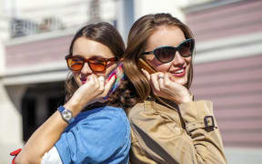 Two women talking on phones