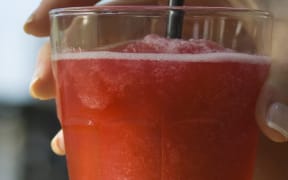 Woman holding daiquiri, cropped view