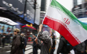 A man holds a Iranian flag during an anti-war protest, at Times Square in New York on January 4, 2020.