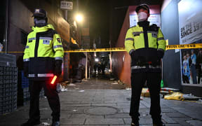 EDITORS NOTE: Graphic content / Police stand guard to restrict access to the alley where a Halloween stampede took place in the neighbourhood of Itaewon in Seoul on October 30, 2022. - More than 140 people were killed on October 29 and some 150 were injured in a horrific stampede in central Seoul when a large crowd celebrating Halloween crammed into a narrow street, officials said. (Photo by Anthony WALLACE / AFP)