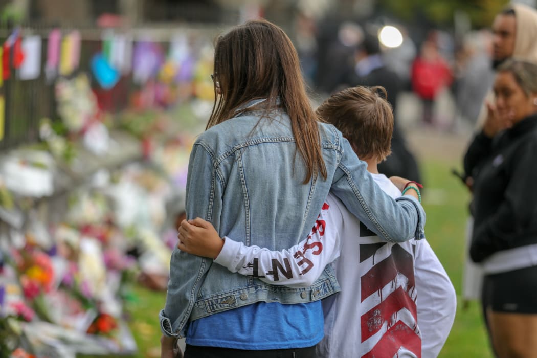 Christchurch Botanic Gardens wall with hundreds of flowers laid in memory of those lost in the mosque shooting