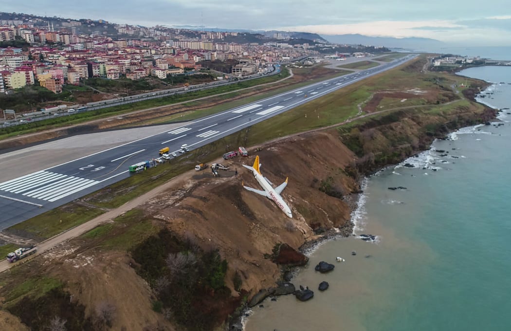 A Pegasus Airlines Boeing 737 passenger plane is seen stuck in mud on an embankment, a day after skidding off the airstrip, after landing at Trabzon's airport on the Black Sea coast on January 14, 2018.