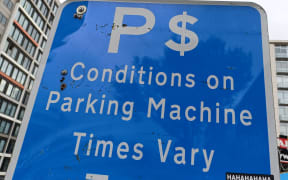 A sign advertising parking services in Auckland.