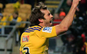 The Hurricanes captain Conrad Smith celebrates scoring a try.