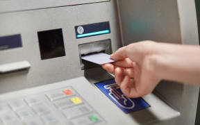 Someone takes off money from outdoor bank terminal, inserts plastic credit card in atm machine, going to withdraw money and get salary. Cash machine. Modern technologies and innovations concept