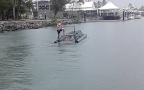 A man standing on top of a baited crocodile trap in Australia.