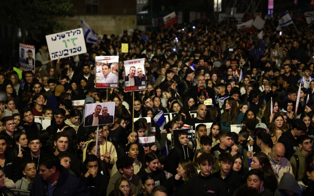 Israelis raise pictures and placards as they march to call for the release of hostages abducted by Palestinian militants during the October 7 attack, in Jerusalem on December 28, 2023, amid ongoing battles between Israel and the Palestinian group Hamas. (Photo by Menahem Kahana / AFP)