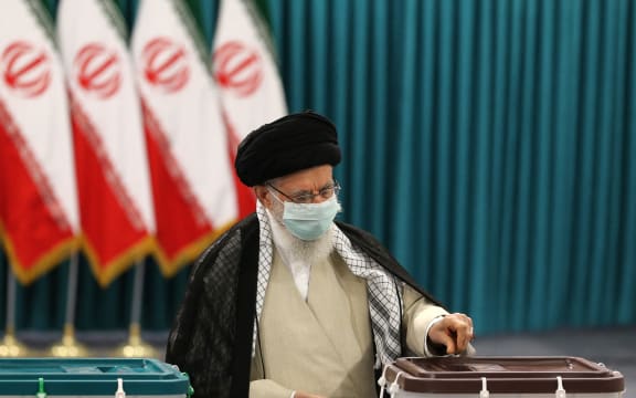 Iran's Supreme Leader Ayatollah Ali Khamenei wears a face mask as he casts his ballot on June 18, 2021.