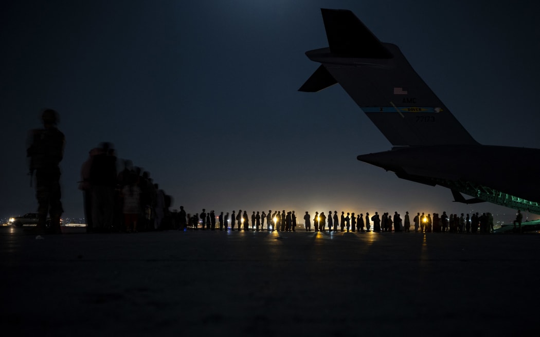 A US Air Force aircrew prepare to load evacuees aboard a US Air Force C-17 Globemaster III aircraft at Hamid Karzai International Airport, Kabul, Afghanistan on 21 August 2021.