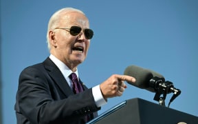 US President Joe Biden gestures as he apologizes for Native American boarding school atrocities at the Gila River Crossing School in the Gila River Indian Community, in Laveen Village, near Phoenix, Arizona on October 25, 2024. - Biden apologized for one of the country's "darkest chapters:" the abduction of Native American children from their families and placement in abusive boarding schools aimed at erasing their culture. The first public apology issued by a sitting US president. From the early 1800s until the 1970s, the US ran hundreds of Indian boarding schools across the country to forcibly assimilate Native children into European settler culture, including conversion to Christianity. (Photo by ANDREW CABALLERO-REYNOLDS / AFP)