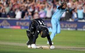New Zealand's Martin Guptill after being run out as England's Jofra Archer celebrates victory in the 2019 Cricket World Cup final