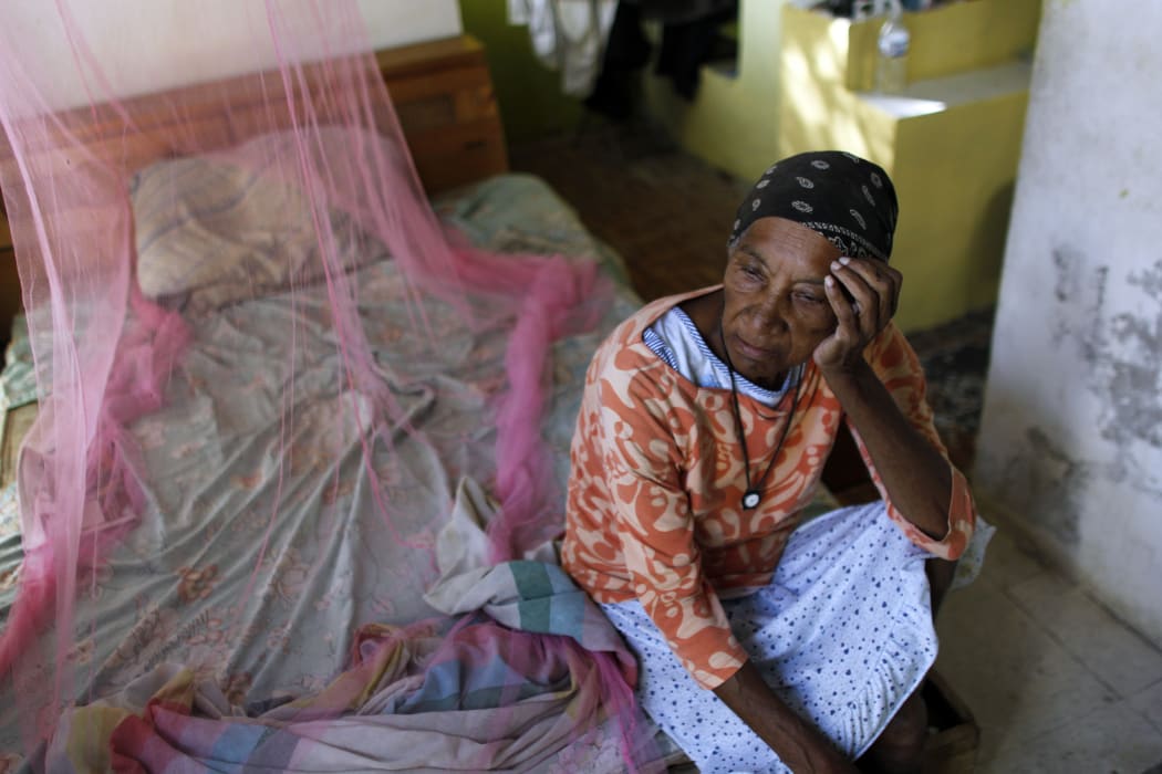 Aurea Cruz, 66 sits on her bed inside her house damaged by Hurricane Maria in Viegues, Puerto Rico.