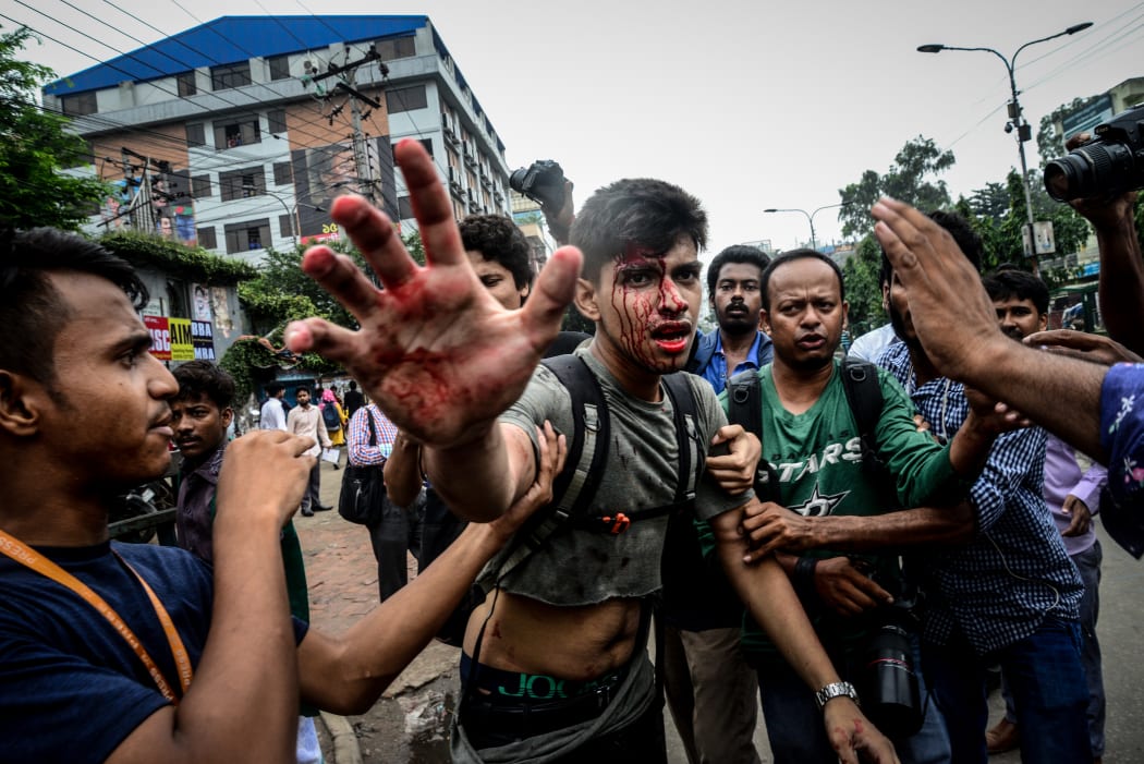 A photographer is targetted during a student protest in Dhaka.