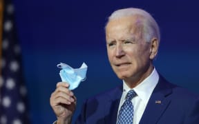 WILMINGTON, DELAWARE - NOVEMBER 09: U.S. President-elect Joe Biden holds a protective mask as he speaks to the media after receiving a briefing from the transition COVID-19 advisory board on November 09, 2020 at the Queen Theater in Wilmington, Delaware.