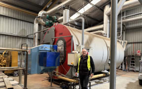 NZ Hothouse managing director Simon Watson at one of two giant gas boilers that help fuel and feed thousands of tomato plants.