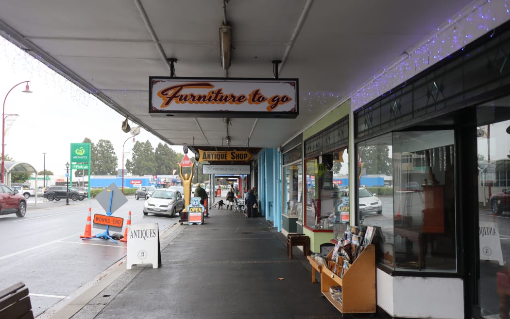 Picture of Paeroa's main street, with many signs of Antique and Op Shops.