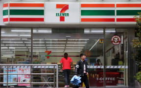 --FILE--A customer exits from a convenience store of 7-Eleven in Shanghai, China, 30 March 2015.