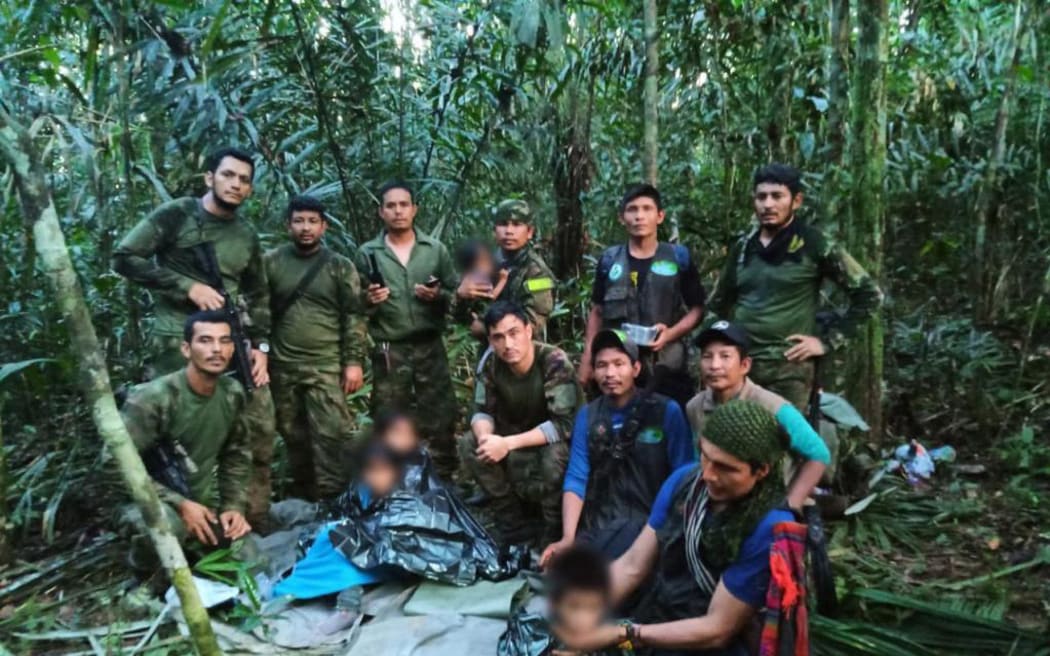 In this handout photo released on June 9, 2023, by the Colombian Presidency, members the Army pose with four Indigenous children who were found alive after spending more than a month lost in the Colombian Amazon jungle following the crash of a small plane. Four Indigenous children were found alive Friday after spending more than a month lost in the Colombian Amazon rainforest following a small plane crash that triggered a massive rescue operation, the country's President Gustavo Petro said. (Photo by Handout / Colombian Presidency / AFP) / RESTRICTED TO EDITORIAL USE - MANDATORY CREDIT "AFP PHOTO / Colombian Presidency" - NO MARKETING - NO ADVERTISING CAMPAIGNS - DISTRIBUTED AS A SERVICE TO CLIENTS