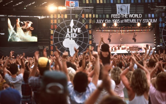 Fans cheer during the performance of "Queen" singer Freddie Mercury. The biggest rock concert of all times, organised by Irish musician Bob Geldof, took place in London and Philadelphia/US on the 13th and 14th of July in 1985 and was broadcasted live via satellite to more than 25 countries.