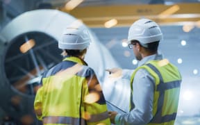 Two Heavy Industry Engineers Stand in Pipe Manufacturing Factory,