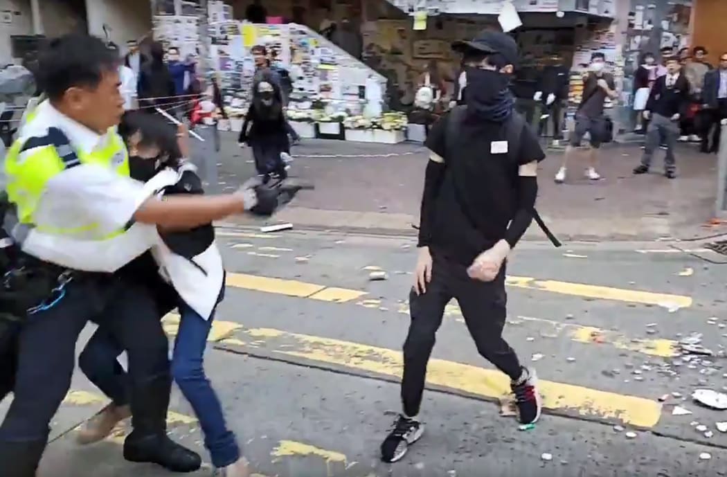 A video grab taken from Cupid News on 11 November, 2019 shows a police man (L) shooting a pro-democracy protester in the chest during a protest in Sai Wan Ho district, in Hong Kong.