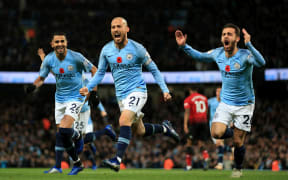 David Silva of Manchester City celebrates with teammates Riyad Mahrez and Bernardo Silva.