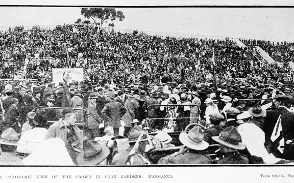 A panoramic view of the crowd celebrating the Armistice in Cook Gardens, Whanganui. 1918.