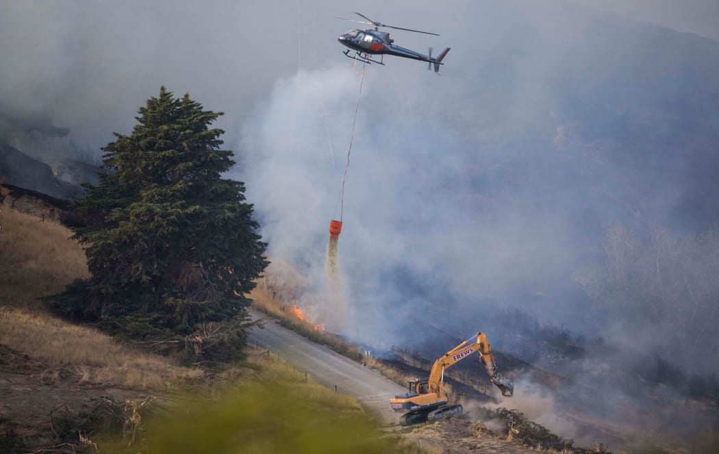 Helicopters and heavy earth-moving equipment are part of the fire response.
