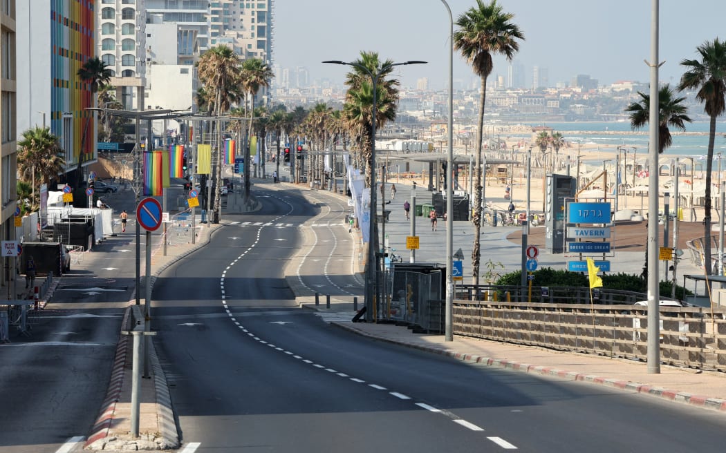 The pride flag decorates an empty street in Tel Aviv on 13 June, 2025, after the city's annual Pride Parade has been cancelled.