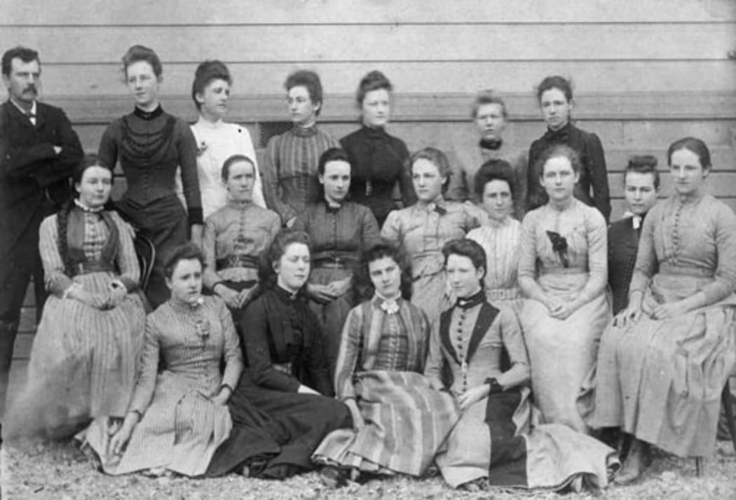A group of form six students from  Wellington Girls' College pose for a photo with language teacher Charles Naverne in 1891.