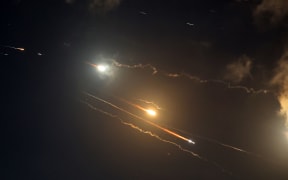 Rocket trails are seen in the sky above the Israeli coastal city of Netanya amid a fresh barrage of Iranian missile attacks on June 16, 2025. Israel's military warned on June 16 that it had detected a new missile salvo from Iran, saying its defensive systems were working against the threat. (Photo by JACK GUEZ / AFP)
