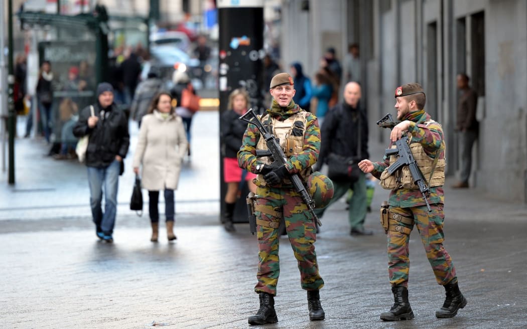 Soldiers patrol streets in Brussels as the alert status is raised to the highest level.