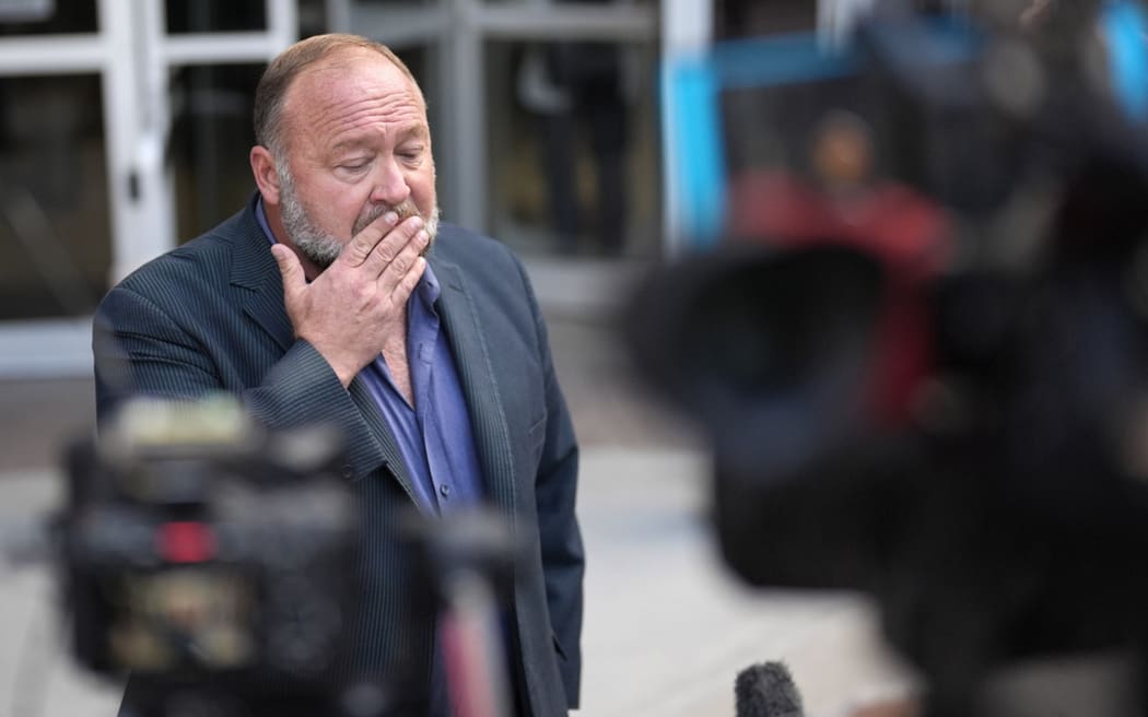 Alex Jones pauses before speaking to the media after arriving at the federal courthouse for a hearing in front of a bankruptcy judge Friday, 14 June, 2024, in Houston.
