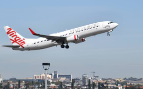 A Virgin Australia plane takes off at Sydney Airport in Sydney on March 19, 2020. -