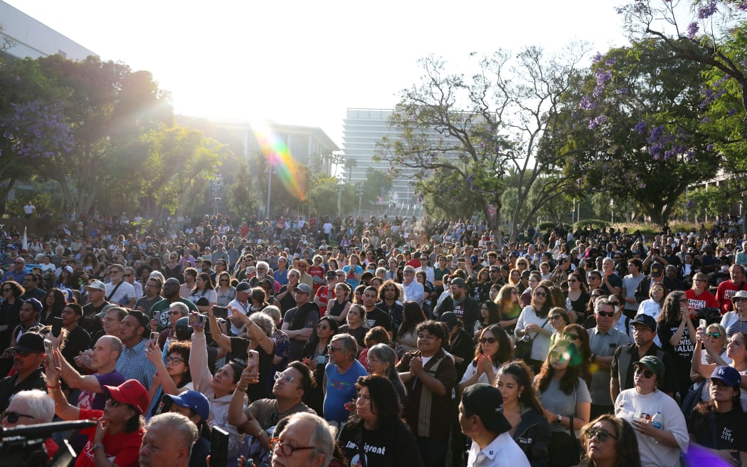 People attend a prayer vigil in Grand Park as curfew goes in effect after days of protests in Los Angeles.