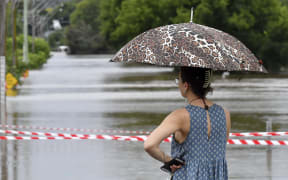 A resident watches the rising floodwaters due to the heavy rain in residential area of southwestern Camden suburb of Sydney on March 8, 2022.