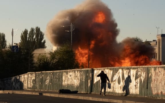 A man falls on the ground following a drone attack in Kyiv on October 17, 2022, amid the Russian invasion of Ukraine. (Photo by Yasuyoshi CHIBA / AFP)