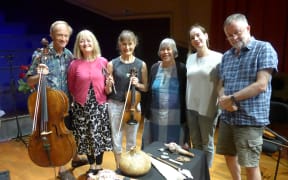 Dame Gillian Whitehead with Bob Bickerton and the New Zealand String Quartet pose on stage with taonga puoro