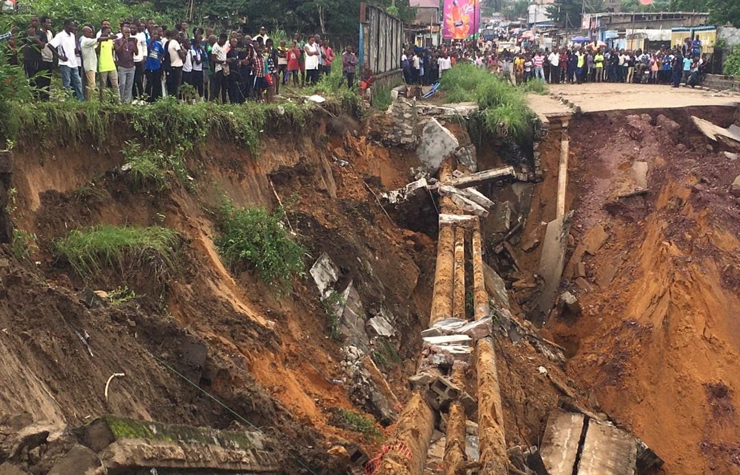 A road surface swept away by a landslide caused by torrential overnight rains is photographed in the Lemba district of Kinshasa, on November 26, 2019.