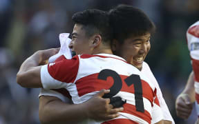 Japan's prop Kensuke Hatakeyama (L) embraces Japan's scrum half Atsushi Hiwasa (R) after winning the Pool B match of the 2015 Rugby World Cup with South Africa.
