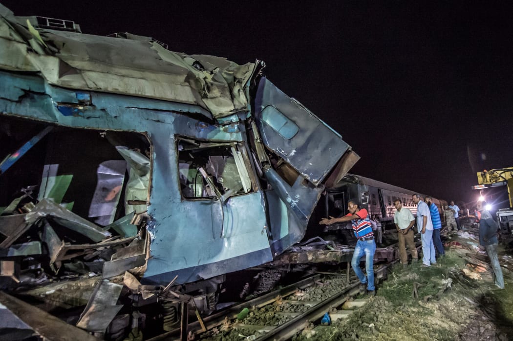 Emergency personnel and Egyptian military police search the wreckage of the train collision.