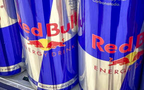 Close-up of Red Bull cans in a supermarket aisle. (Photo by Philippe TURPIN / Photononstop / Photononstop via AFP)