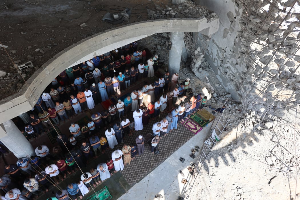 Palestinian Muslim worshippers attend friday prayers amidst the rubble of the destroyed Albaani Mosque in Khan Yunis in the southern Gaza Strip on October 17, 2025. Hamas said it was committed to the US-brokered agreement that halted its war with Israel, and to returning all the bodies of hostages still unaccounted for under the ruins of Gaza. (Photo by Omar AL-QATTAA / AFP)