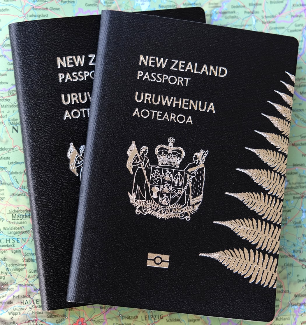 New Zealand passport sits on top of world map.