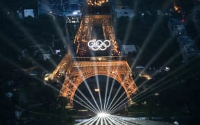 A photograph taken from an helicopter on July 26, 2024 shows an aerial view of the Eiffel Tower and the Olympics Rings lightened up during the opening ceremony of the Paris 2024 Olympic Games in Paris. (Photo by Lionel BONAVENTURE / POOL / AFP)