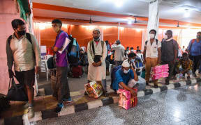 Passengers arrive at Guwahati Railway station and wait in queue to test for COVID-19 coronavirus.