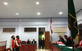 Jakub Skrzypski (L) and Papuan student Simon Magal given jail sentences in court.