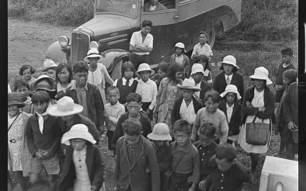 A group of children standing near the Kaikohe Native School bus charabanc., 1940